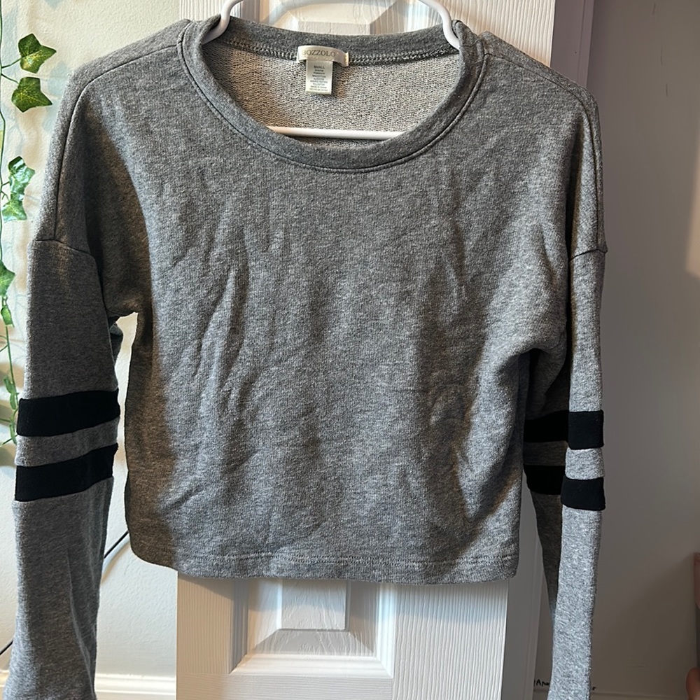 I’m selling a gray sweater with black stripes on the arms and a small.